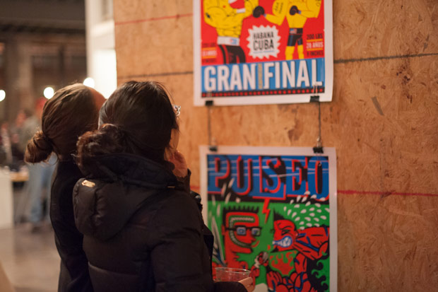 Guest admiring the design at the Cuban Poster Design Exhibit at Atomicdust