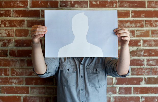 Person holding up a piece of paper with a blank social media avatar