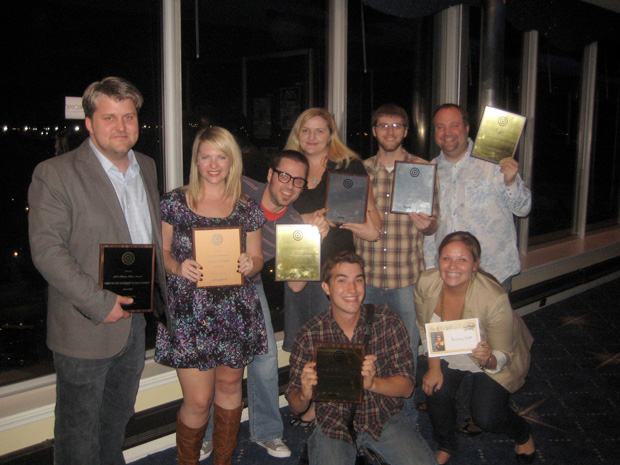 The Atomicdust creative team holds up their marketing and design awards from the BMA.