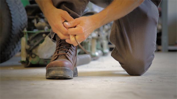 Photo of a man tying the laces of a Reebok Work boot