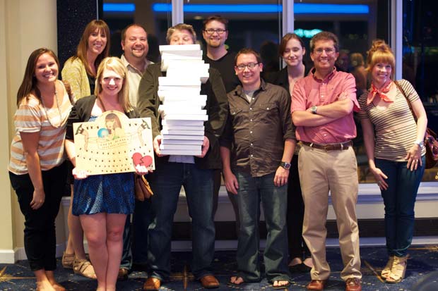 The Atomicdust creative team holding a stack of marketing and advertising awards