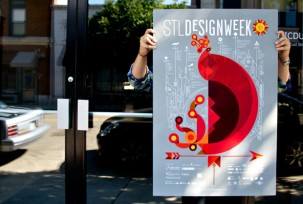 Designer at Atomicdust holding up a poster for St. Louis Design Week