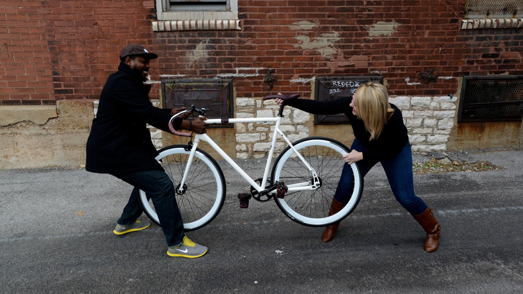 Kevin and Erika have a tug of war over a bike