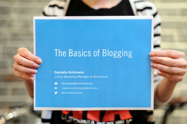 Person holding a sign reading - 'The Basics of Blogging'