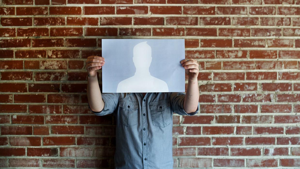 Person holding up a piece of paper with a blank social media avatar at Atomicdust