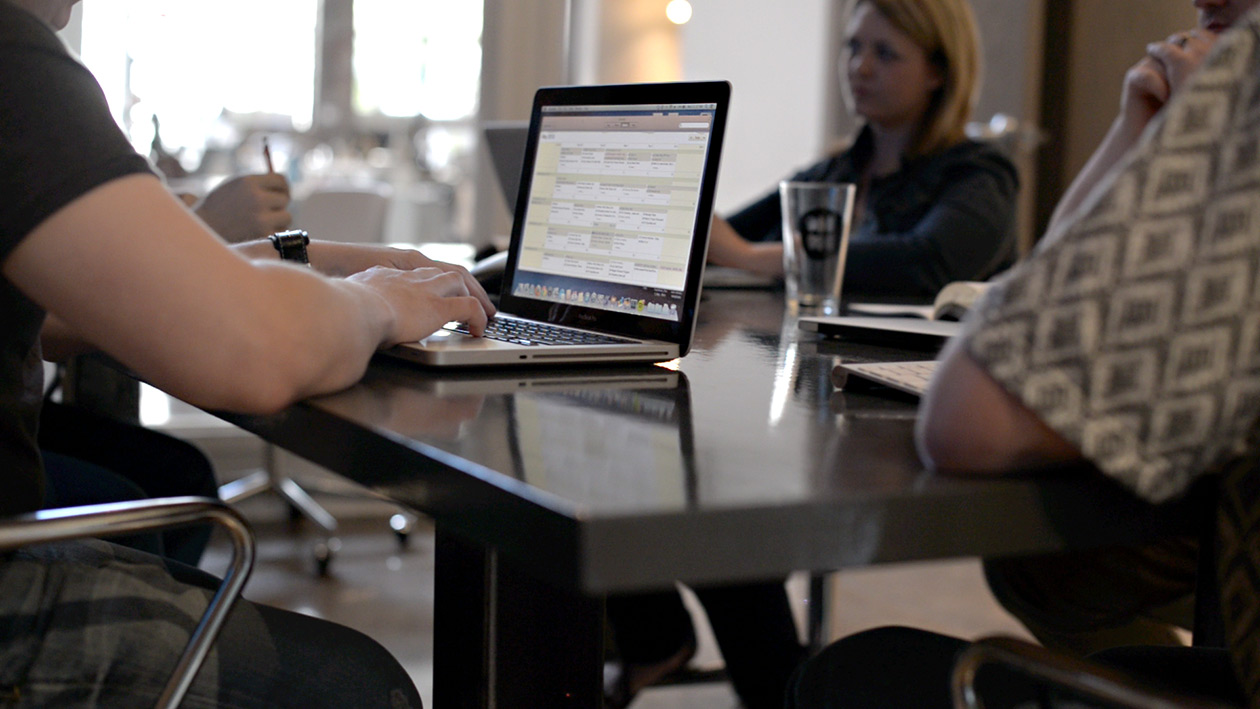 The creative team at Atomicdust around the conference room table with laptops