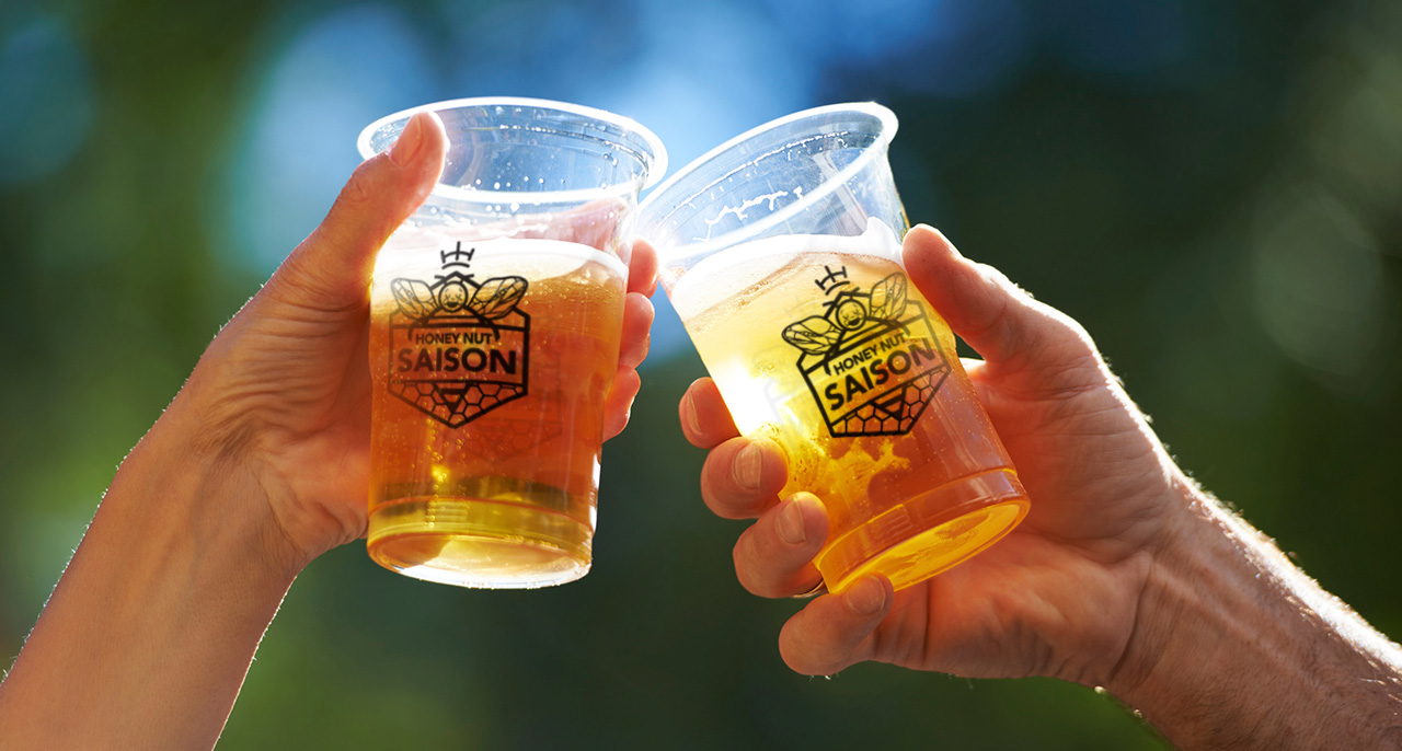 Plastic cups cheer with the Honey Nut Saison logo