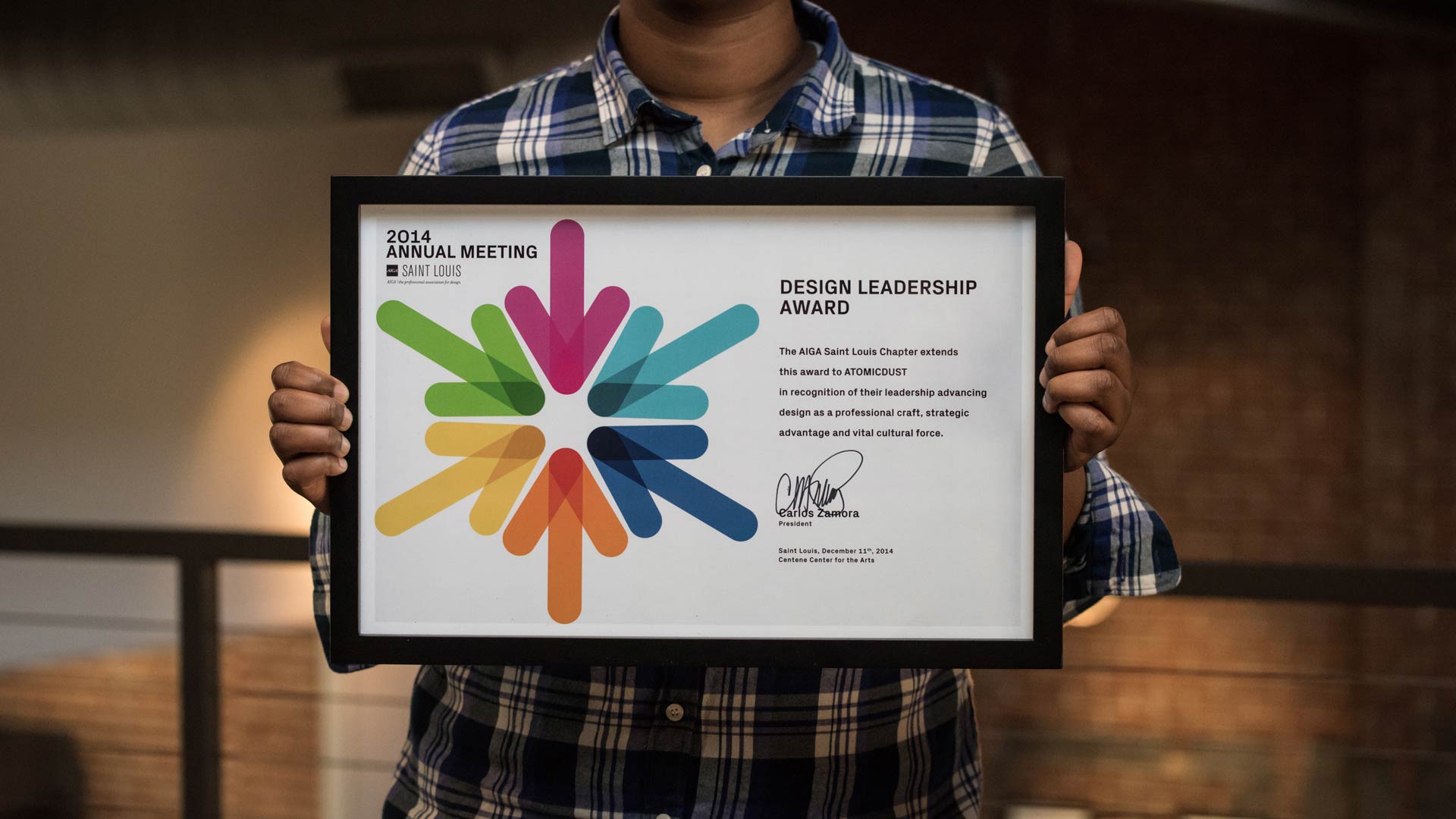 Atomicdust holding up a framed AIGA Design Leadership Award