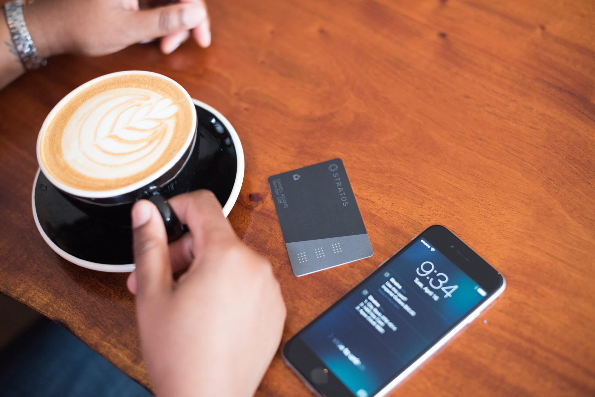 Table with coffee, Stratos Card, and an iPhone