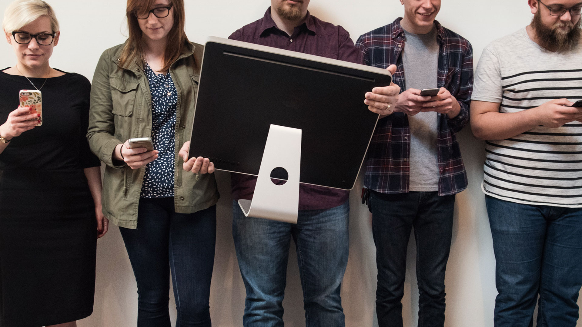 Creatives at Atomidust holding different sized electronic devices