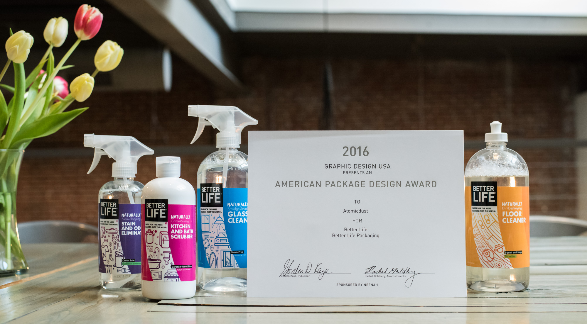 A table with Atomicdust's American Package Design Award and Better Life cleaning products with their new label design.