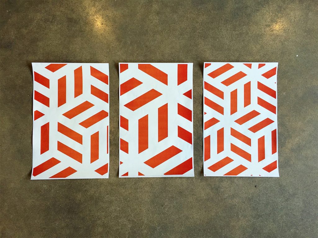 3 printed sheets of branded patterns on a concrete floor
