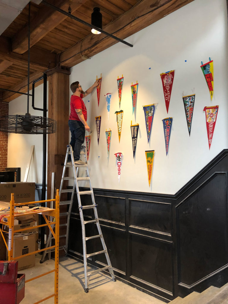 Bill hangs pennants at The Midwestern