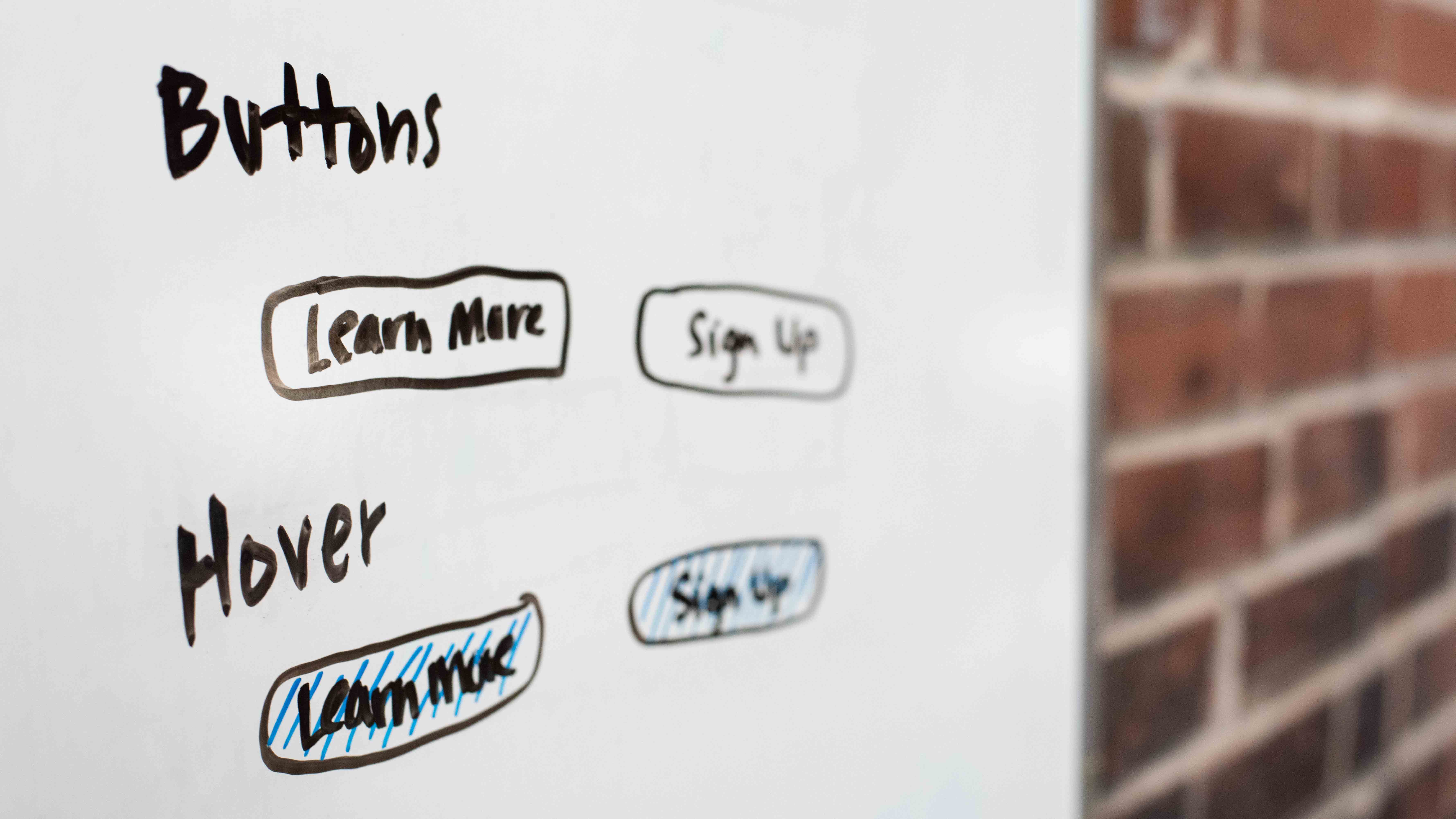 UX whiteboard sketch of button and hover designs