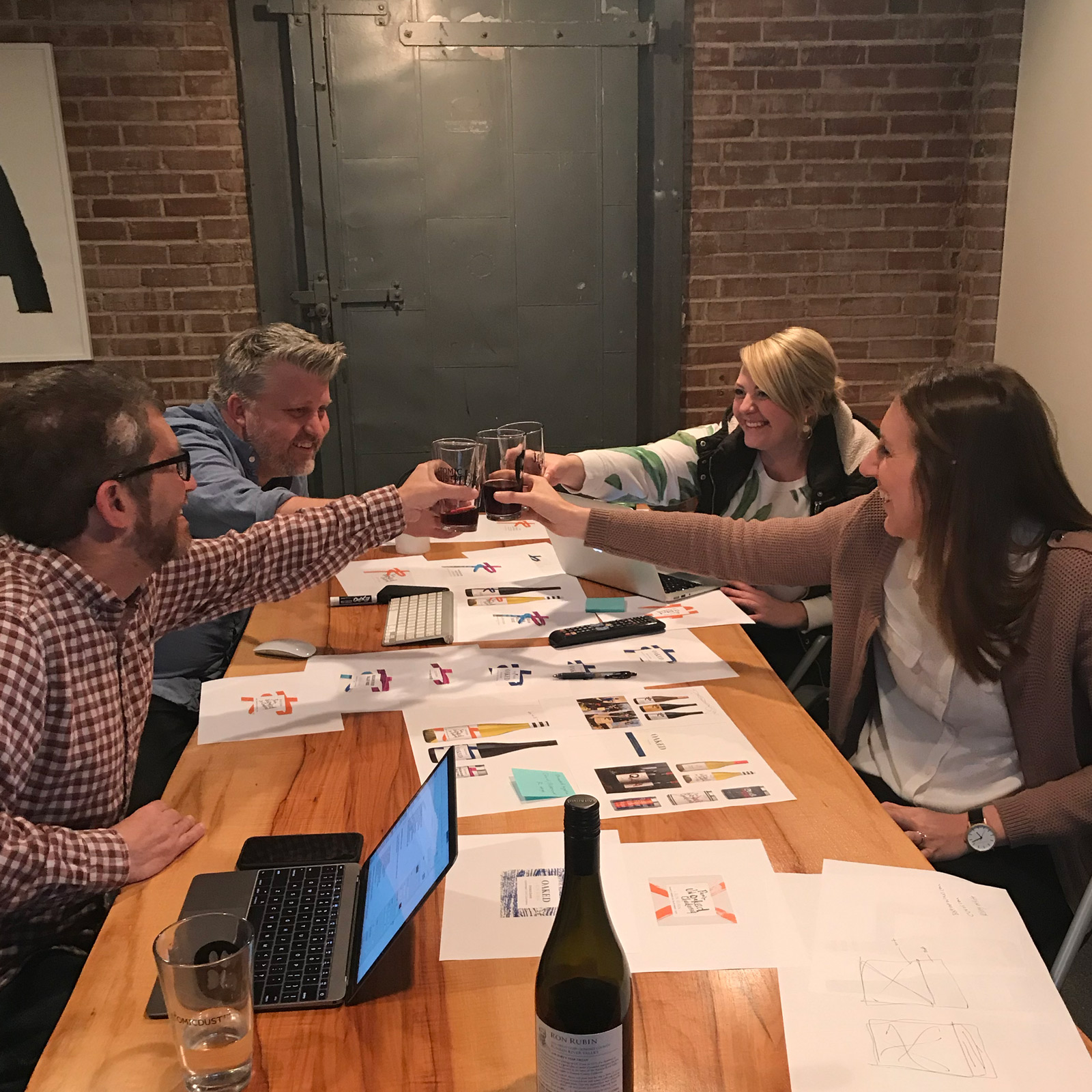The Atomicdust team cheers Ron Rubin wine during a website design meeting