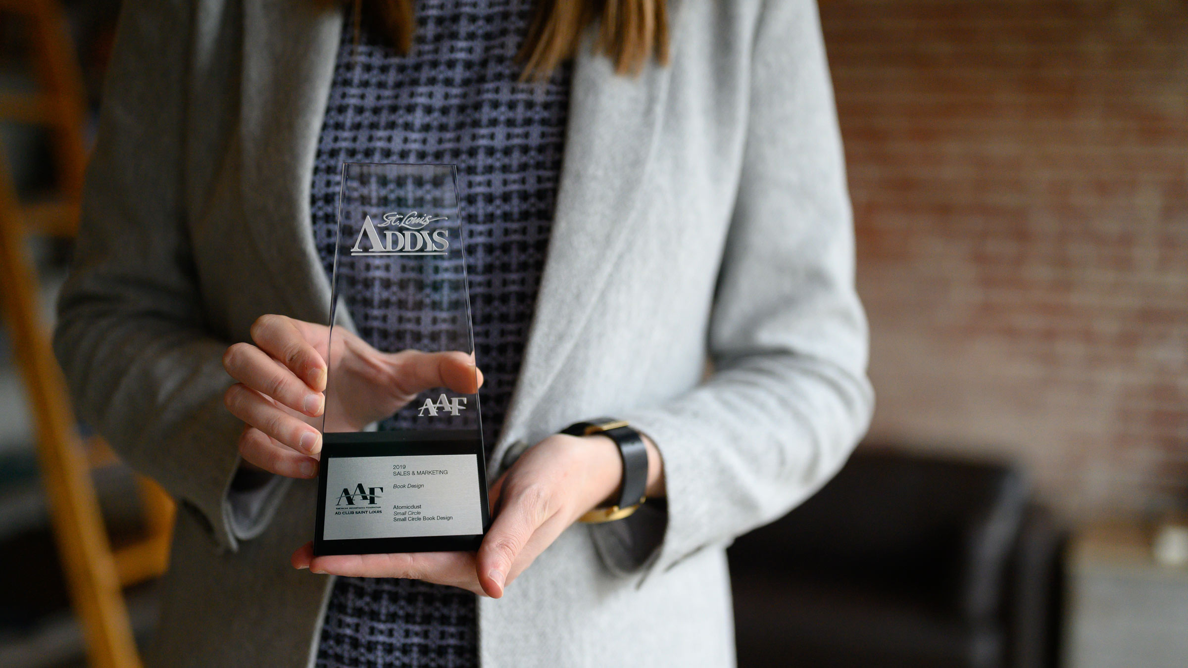 An Atomicdust team member holds our 2020 Gold ADDY trophy