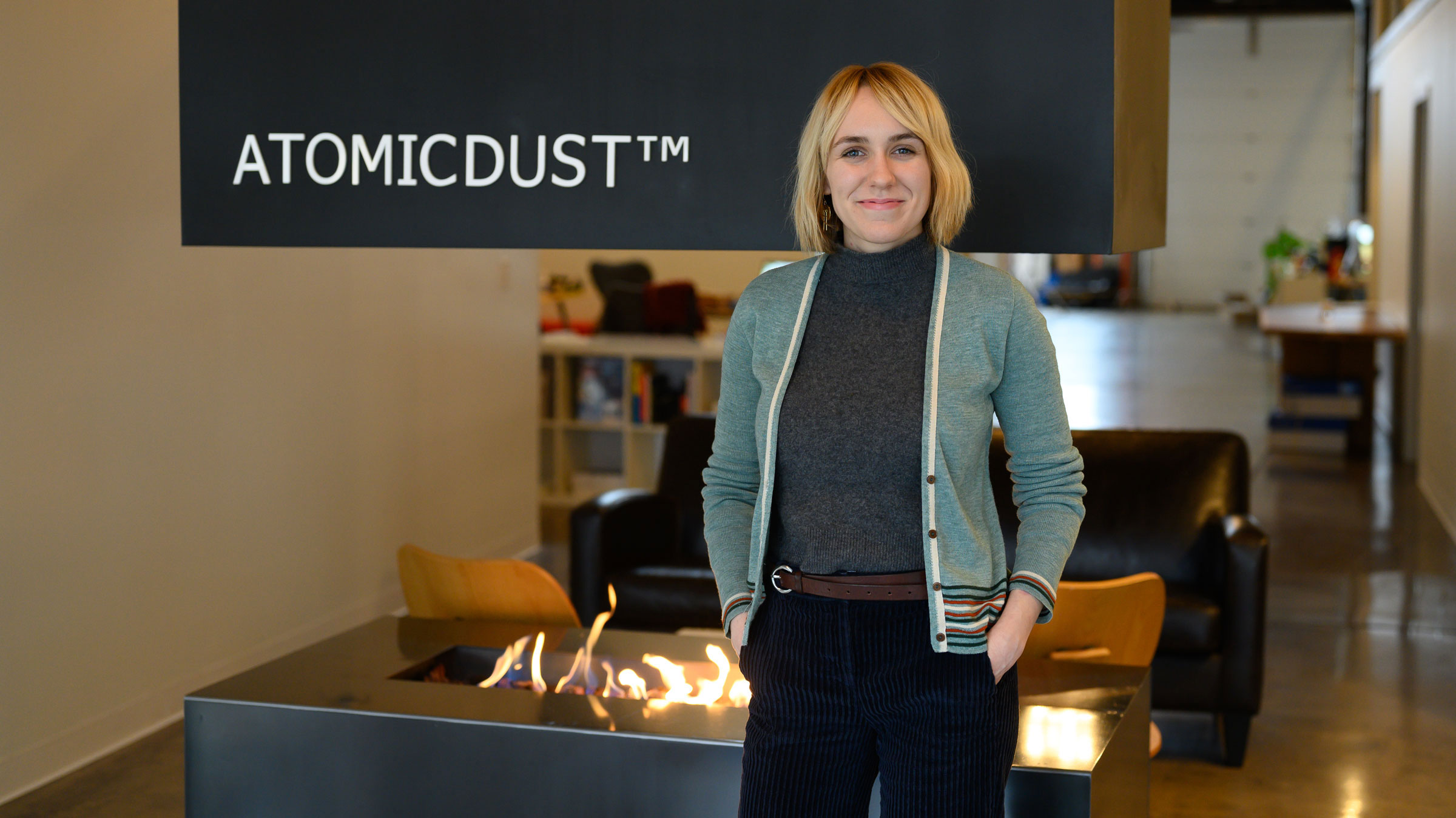 Simone stands in front of the fireplace at the Atomicdust office