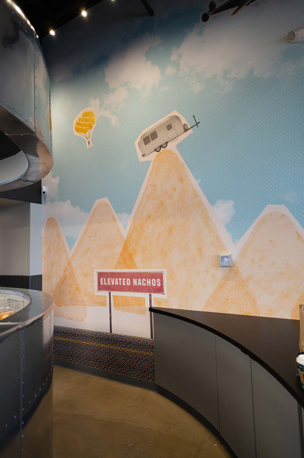 A wall graphic inside Loaded shows an Airstream balanced on the peak of a Chip Mountain