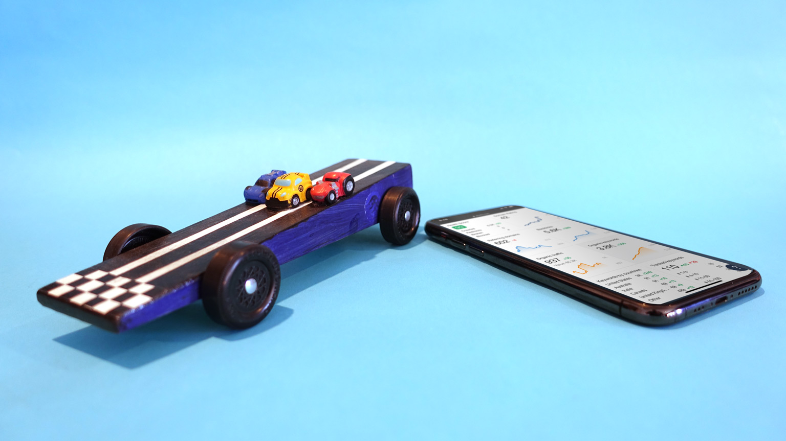 A pinewood derby car and seo software on a mobile phone.