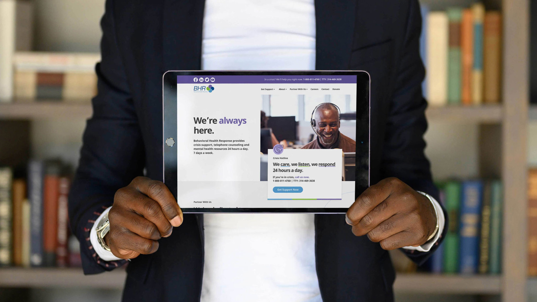 A man holds an iPad with the Behavioral Health Response website design on it