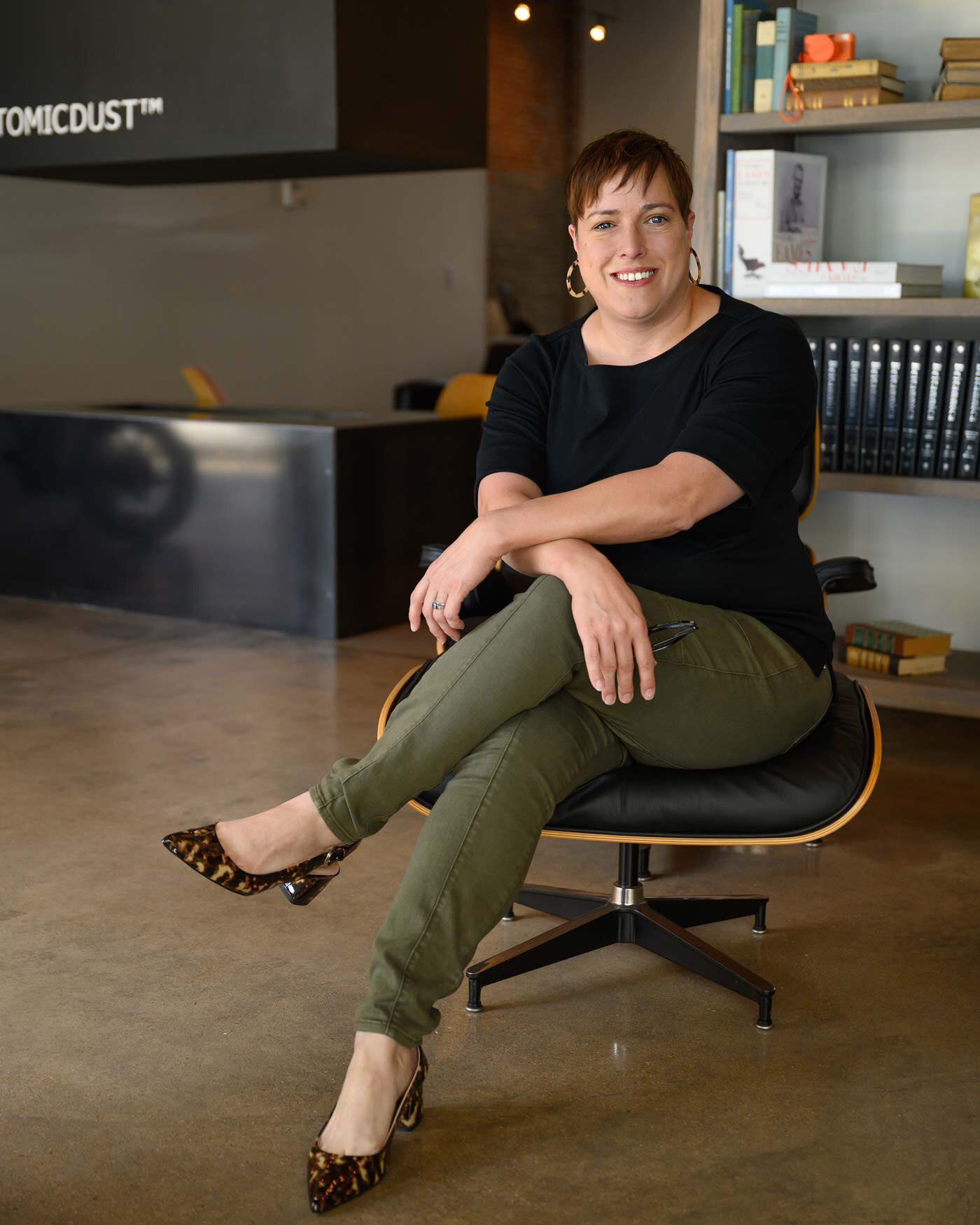 Holly Sinclair sits on an Eames chair in the Atomicdust office