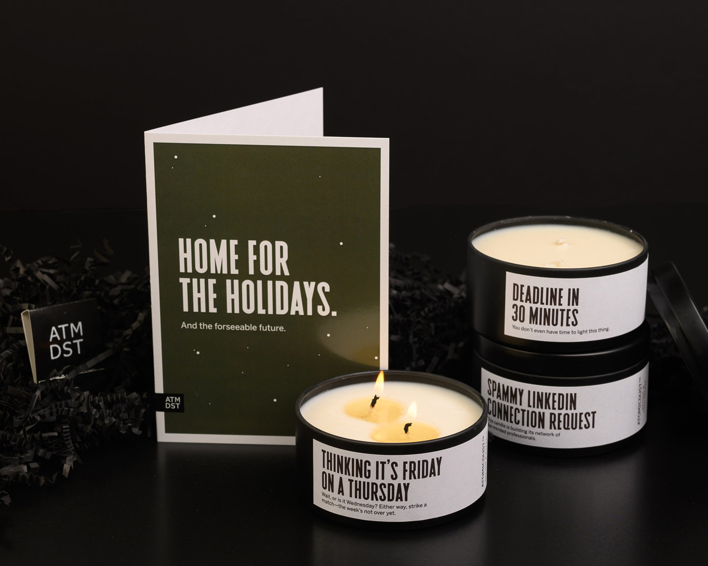 Atomicdust holiday client gifts from 2020, including a card, hand-poured candles with funny labels and custom matches