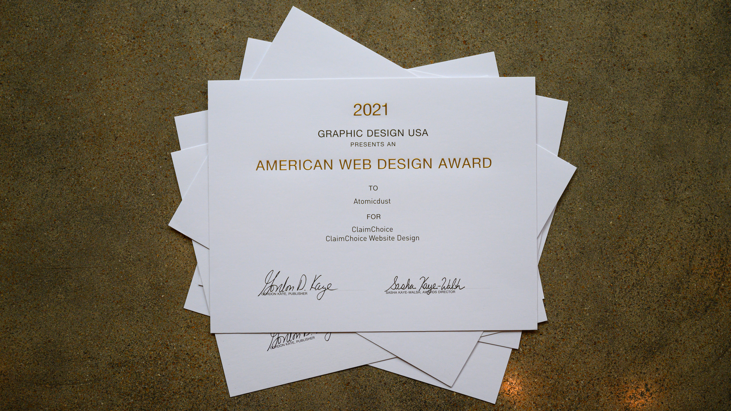 A stack of Atomicdust's 2021 GDUSA American Web Design Awards certificates