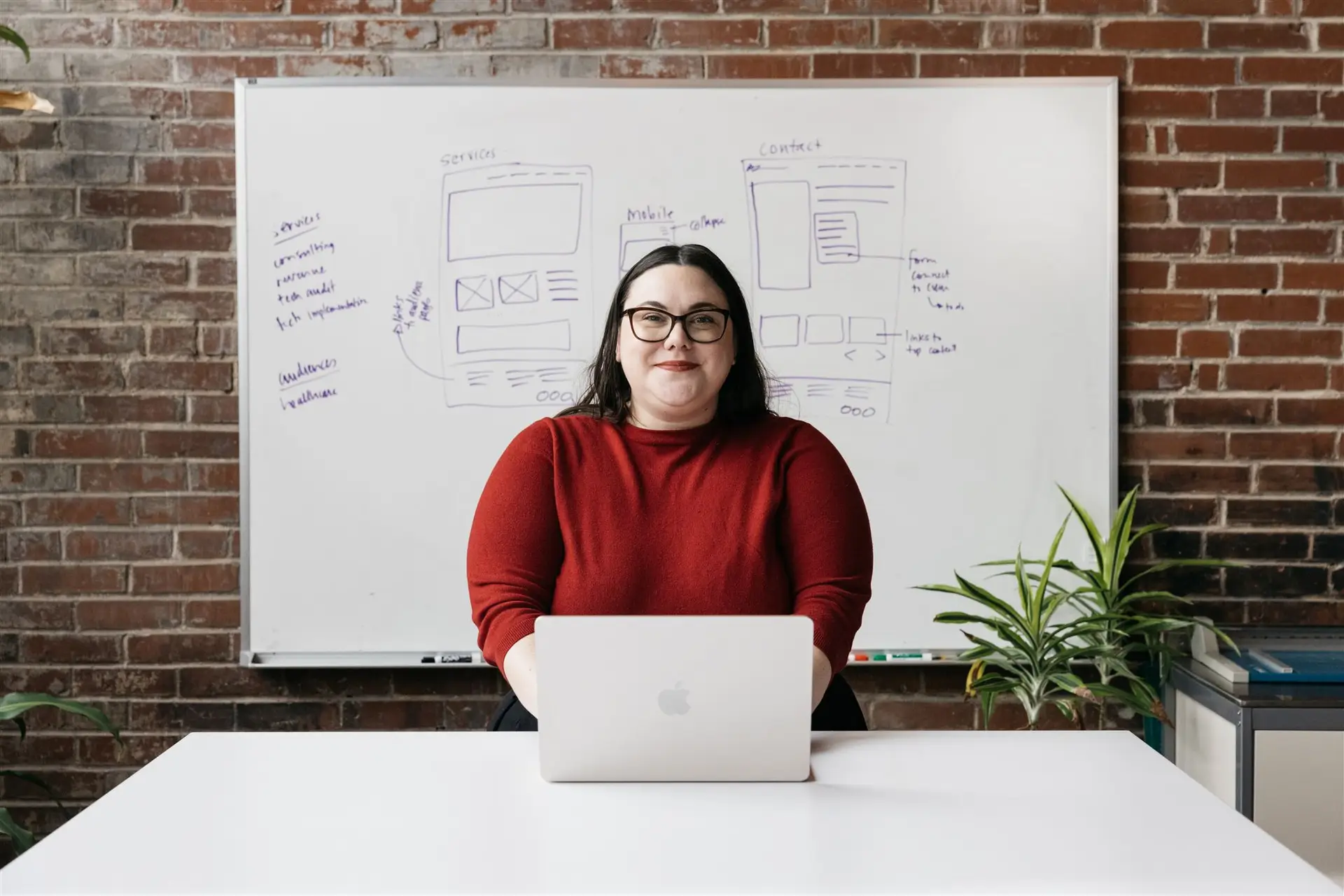 Julie standing in front of the whiteboard at Atomicdust Branding and Marketing Agency in St. Louis