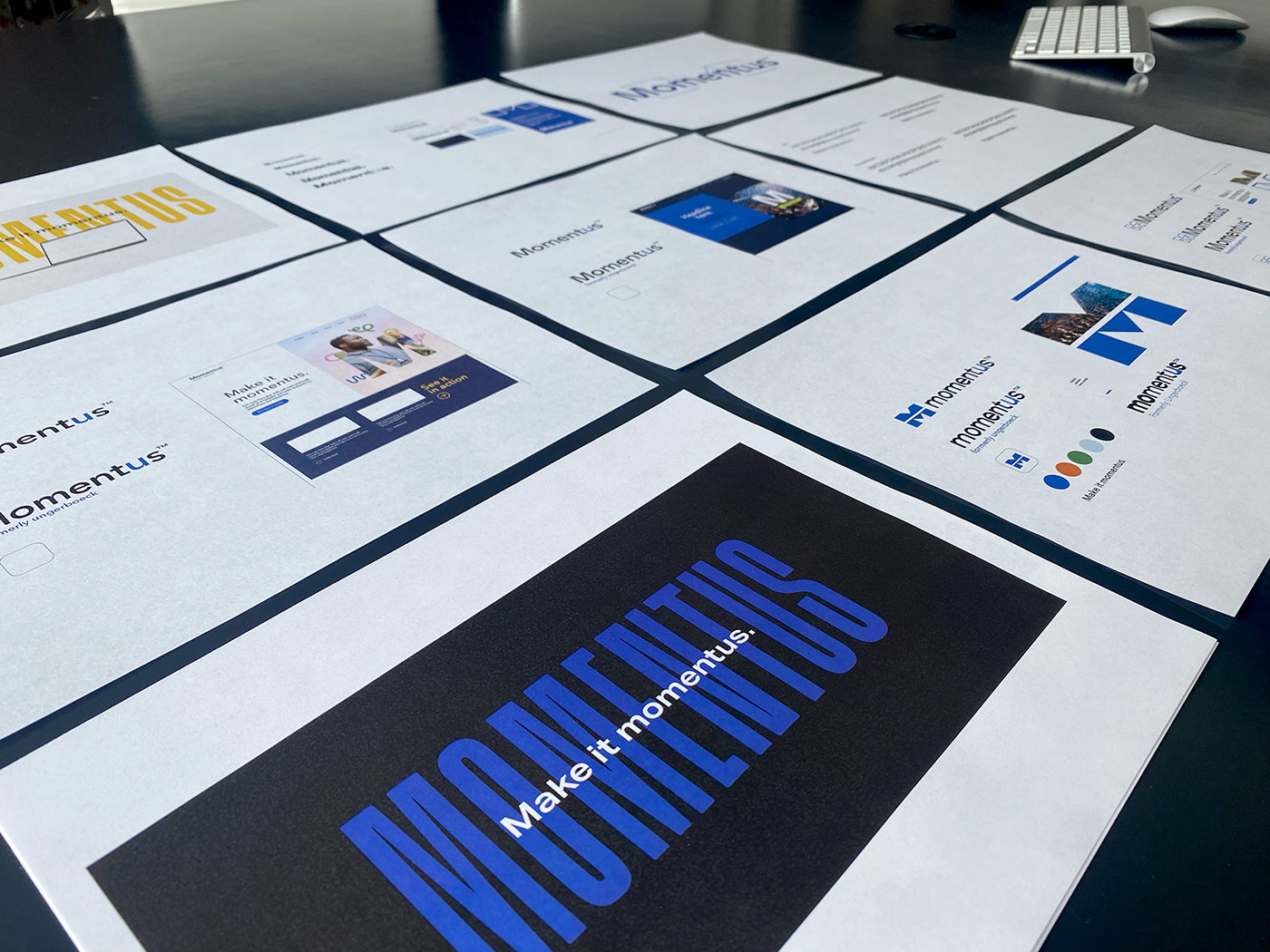 Design concepts of the Momentus brand, printed and laying across the table.