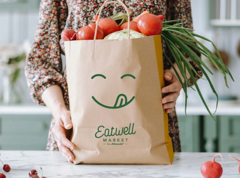 Eatwell Market branding on a paper grocery bag
