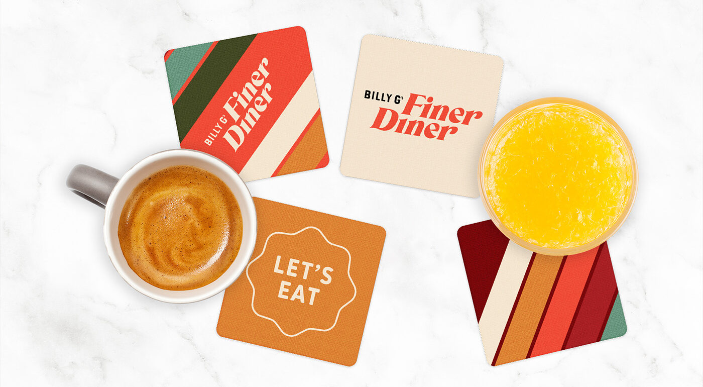 Aerial view of a breakfast table with coasters featuring Billy G's Finer Diner branding