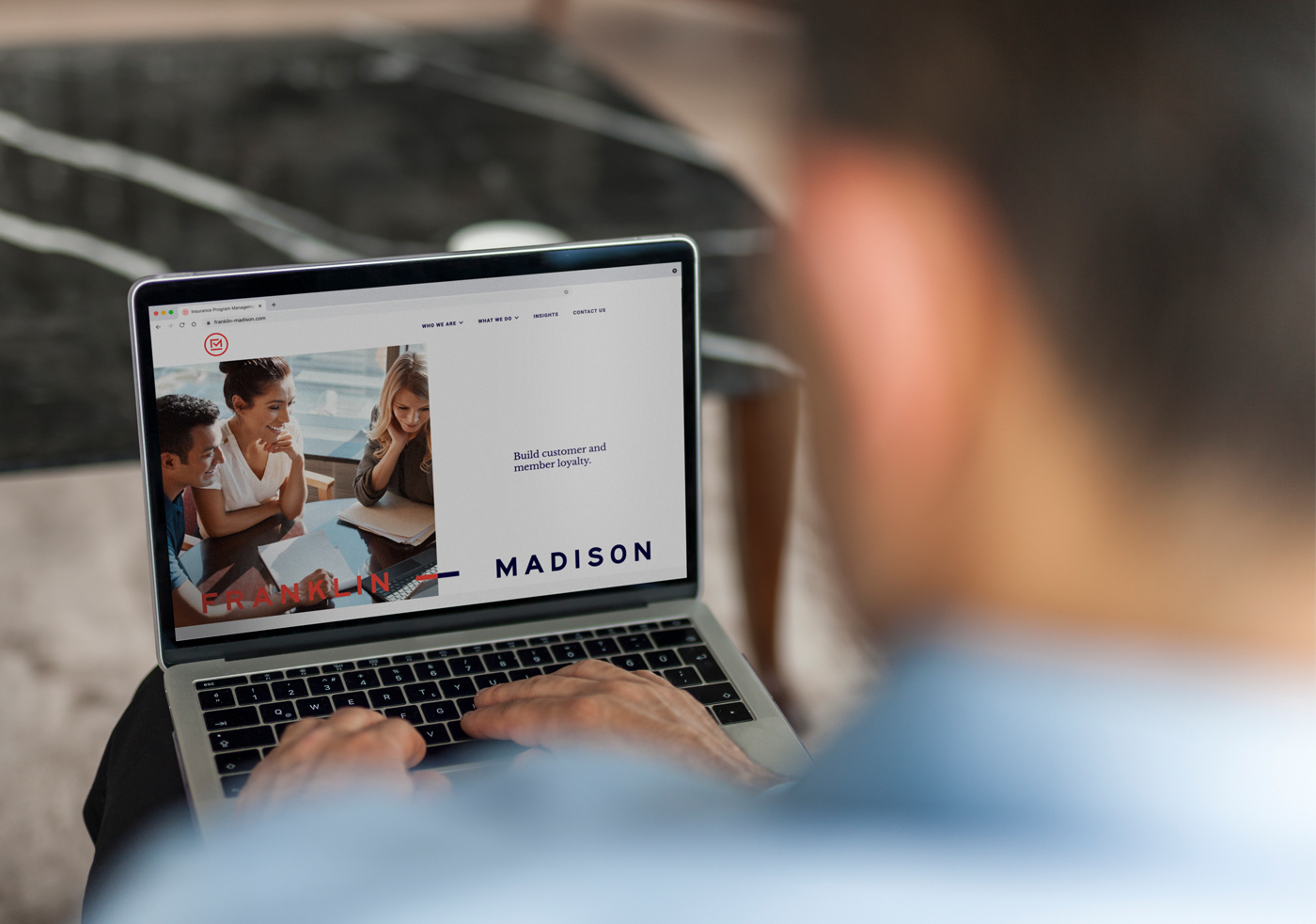 A person looks at the Franklin Madison B2B website design on a laptop