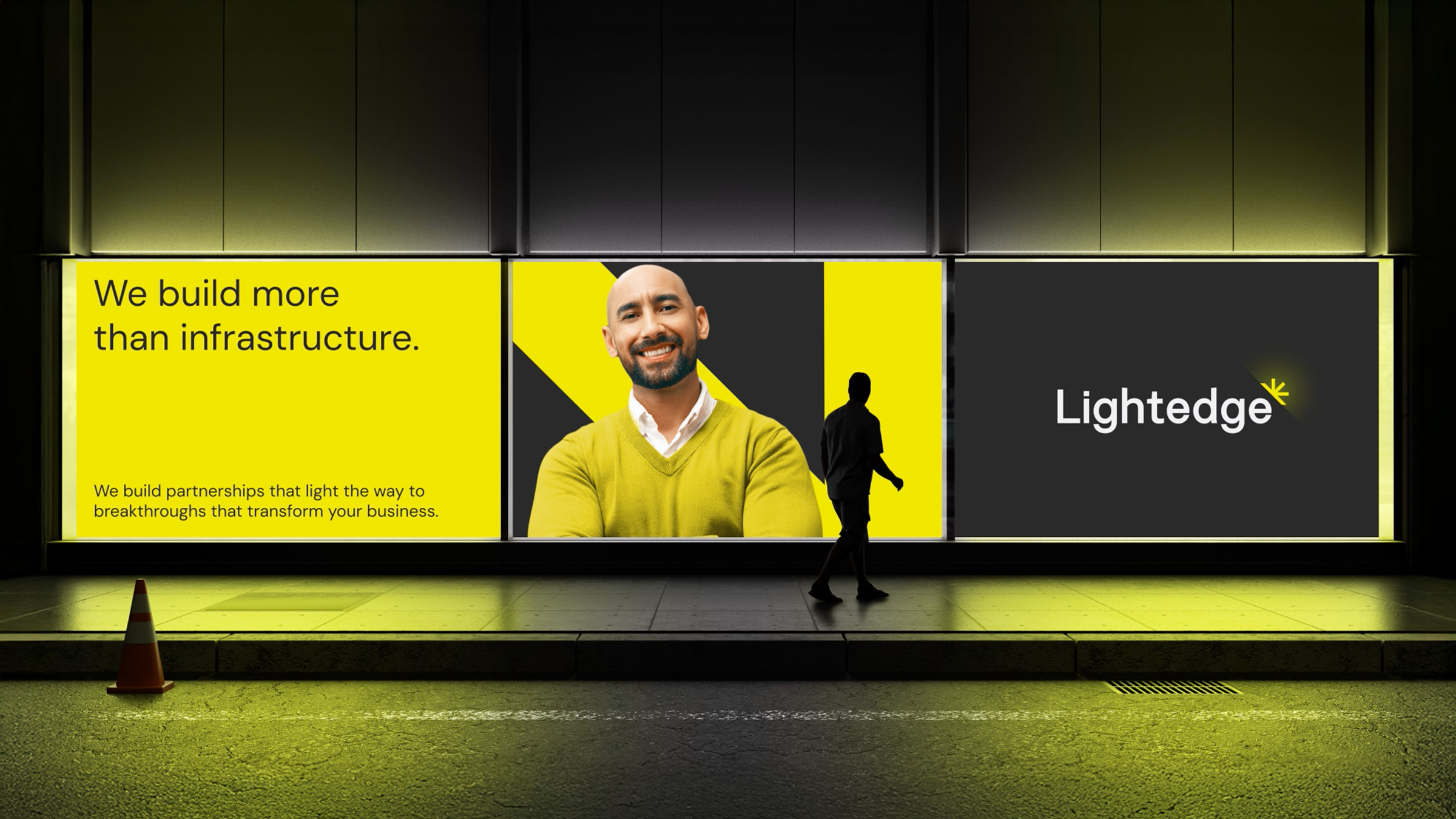 A person walks past a multi-panel digital billboard with tech infrastructure company Lightedge's new brand identity