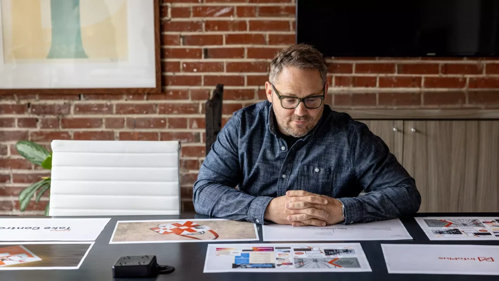 Atomicdust Partner and Account Director Jesse McGowan reviews brand identity designs in the office