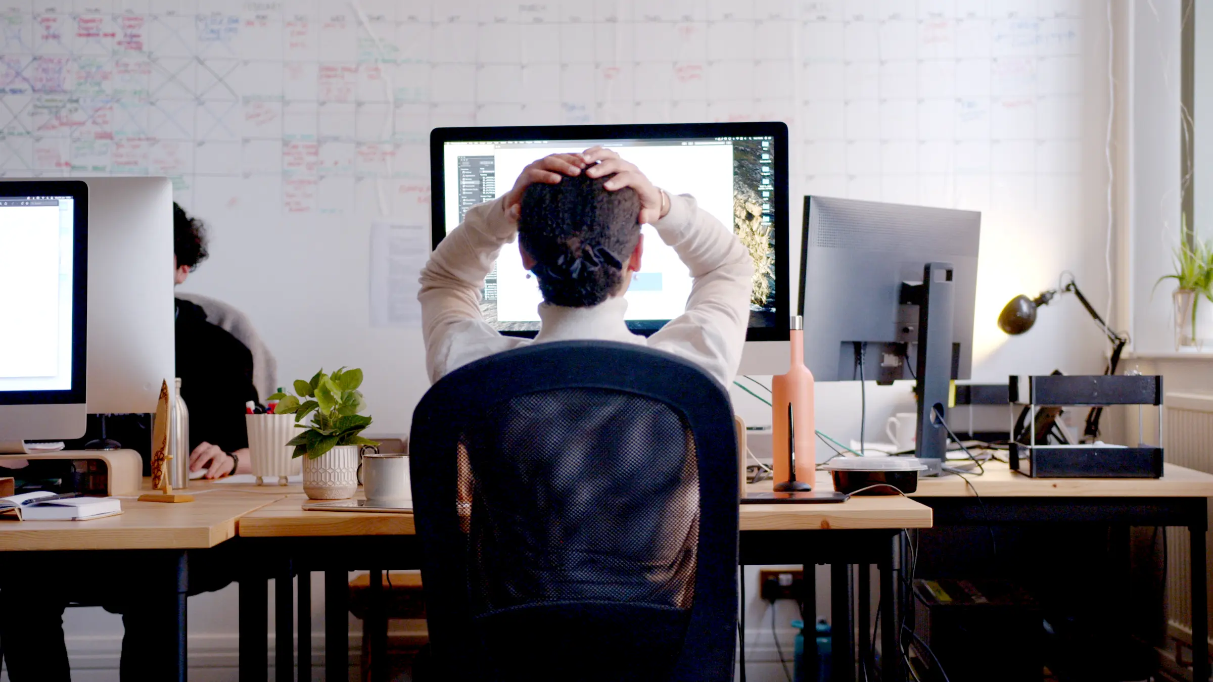 Frustrated woman in front of computer looking at competitor's new rebranding.