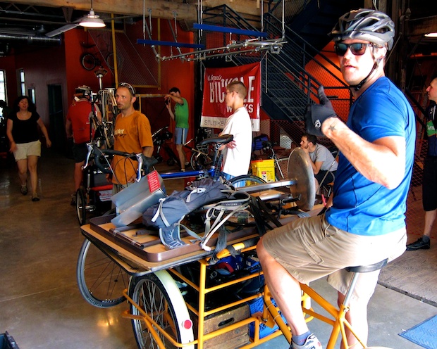 James Dixson sitting on a bicycle, giving a thumbs up
