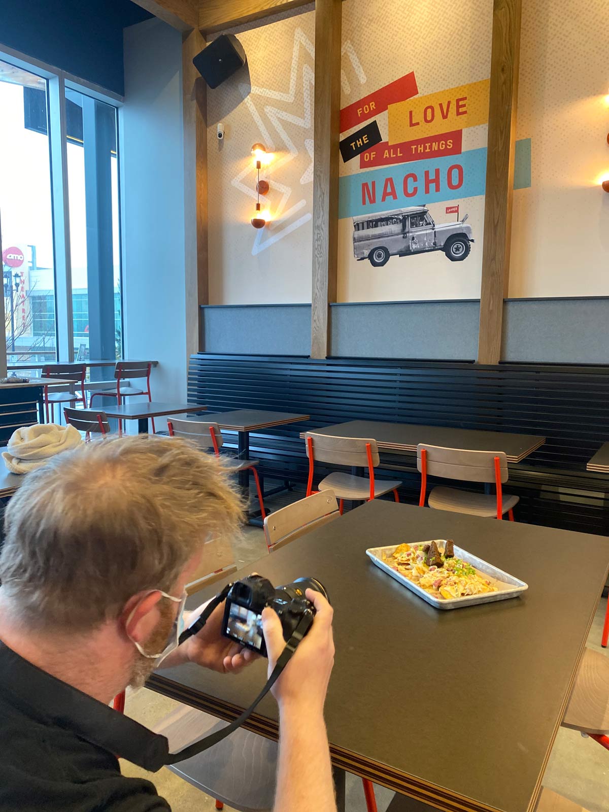 An Atomicdust team member takes photos at Loaded's soft opening