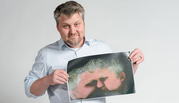 Mike Spakowski holds up a printed scan of his face