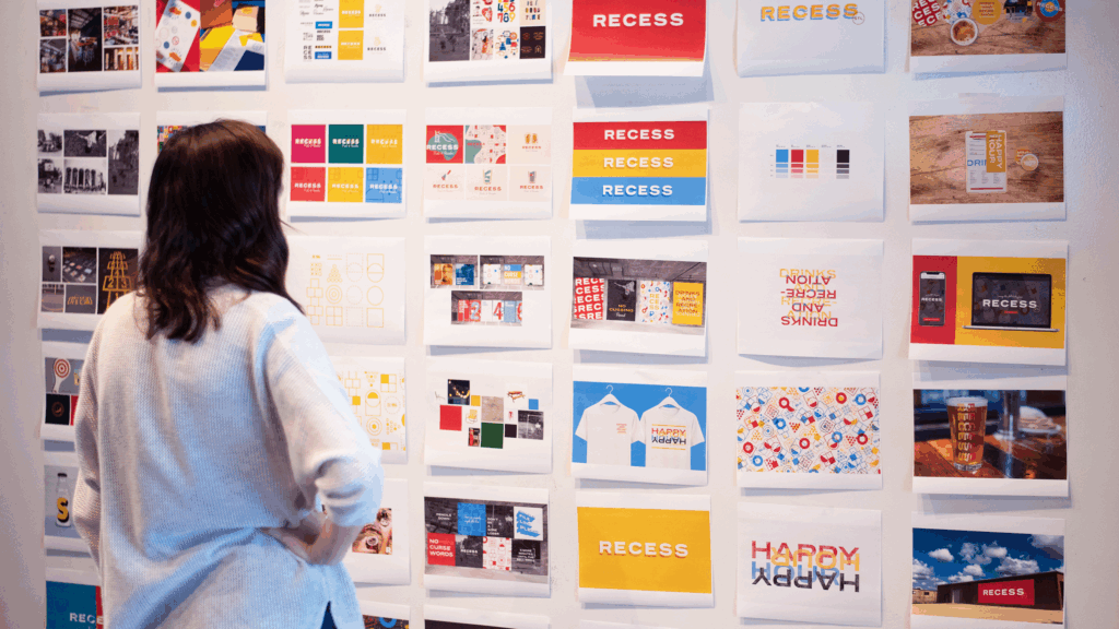 Atomicdust designer looks at Recess branding on a whiteboard