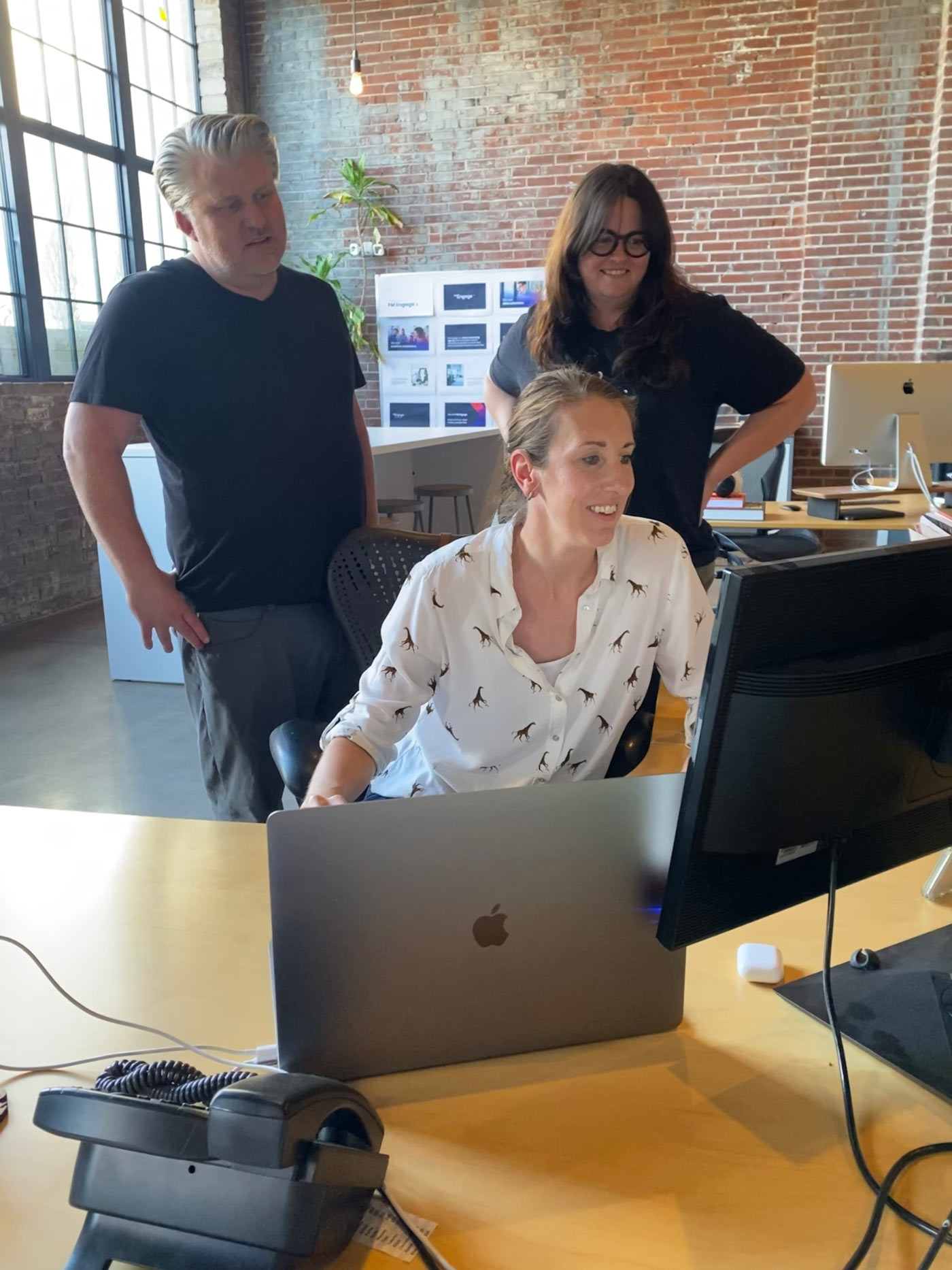 Atomicdust team members look at a design on the computer