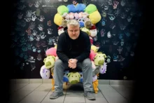Mike Spakowski sits on a throne made of stuffed animals