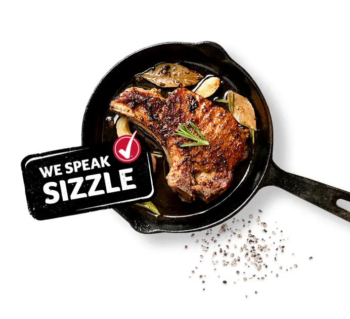 A cast iron skillet with a steak and a Winn-Dixie branded graphic device that says "We speak sizzle!"