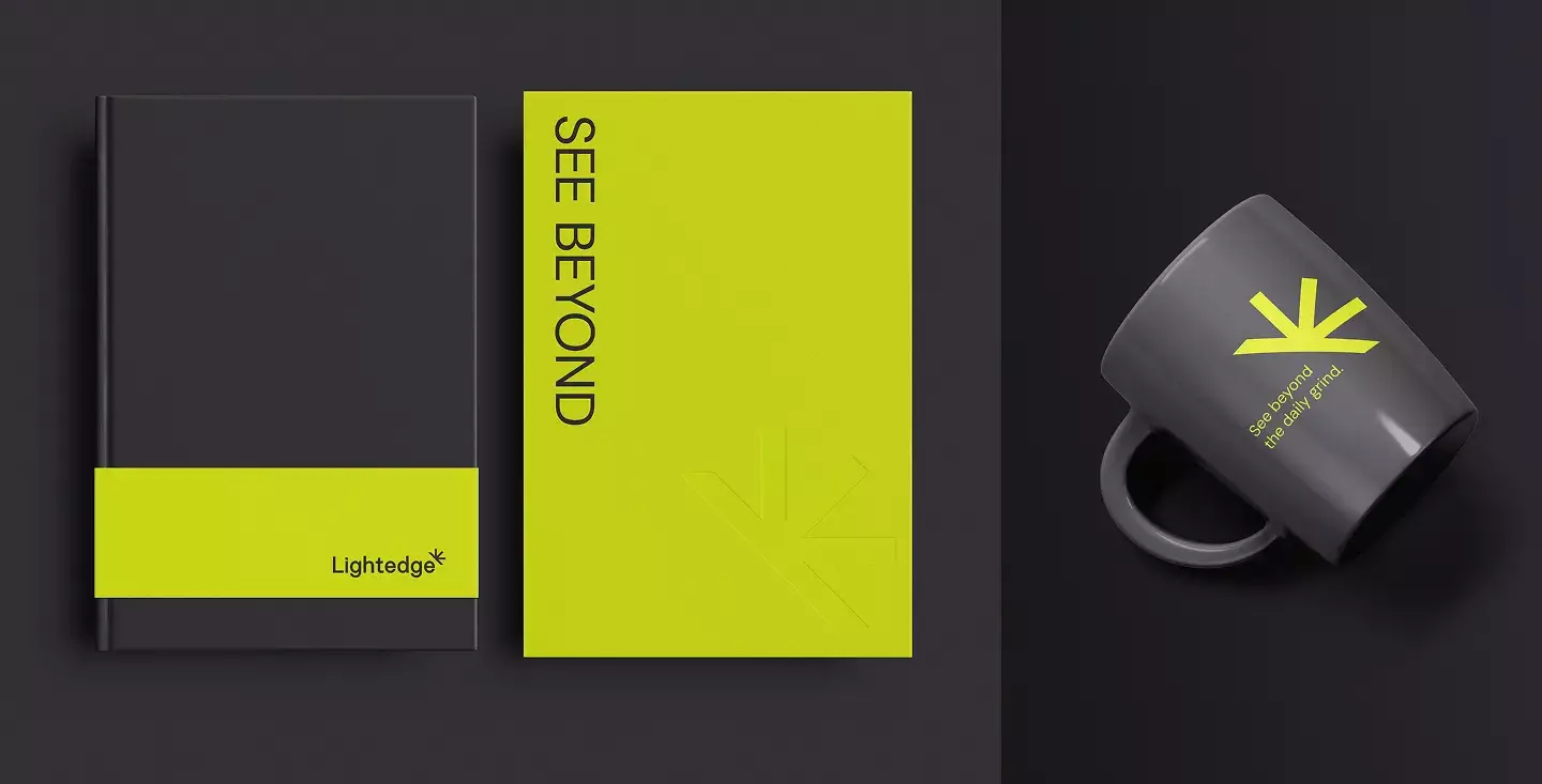Notebooks and a coffee mug featuring Lightedge's new brand identity