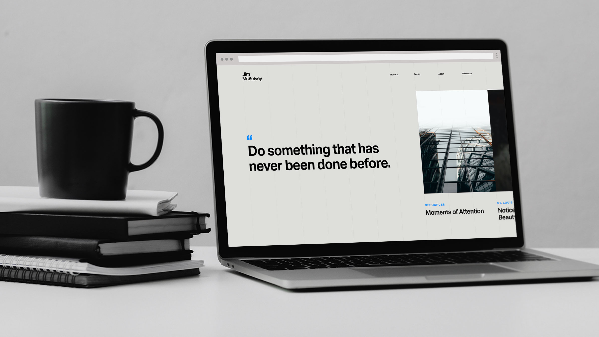 Laptop with Jim McKelvey's website design, next to a coffee mug and books