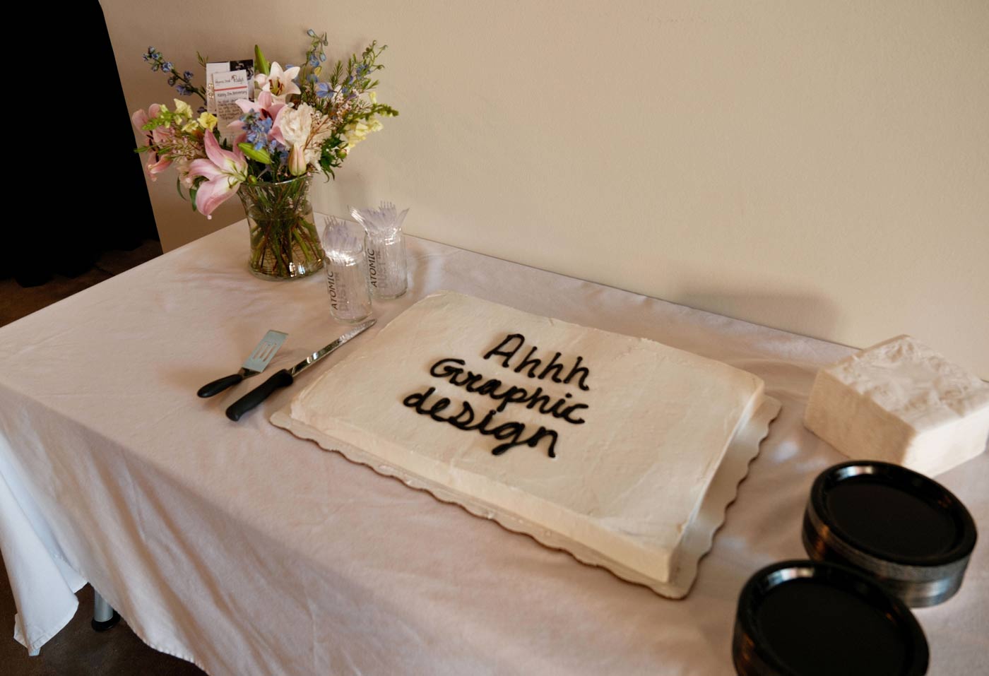 A sheet cake with "Ah graphic design" in icing