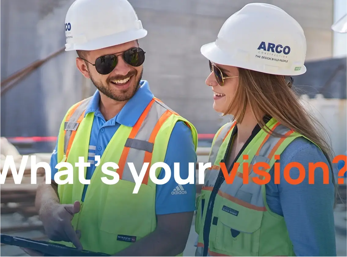 ARCO Construction employees walking on a site, smiling and talking.