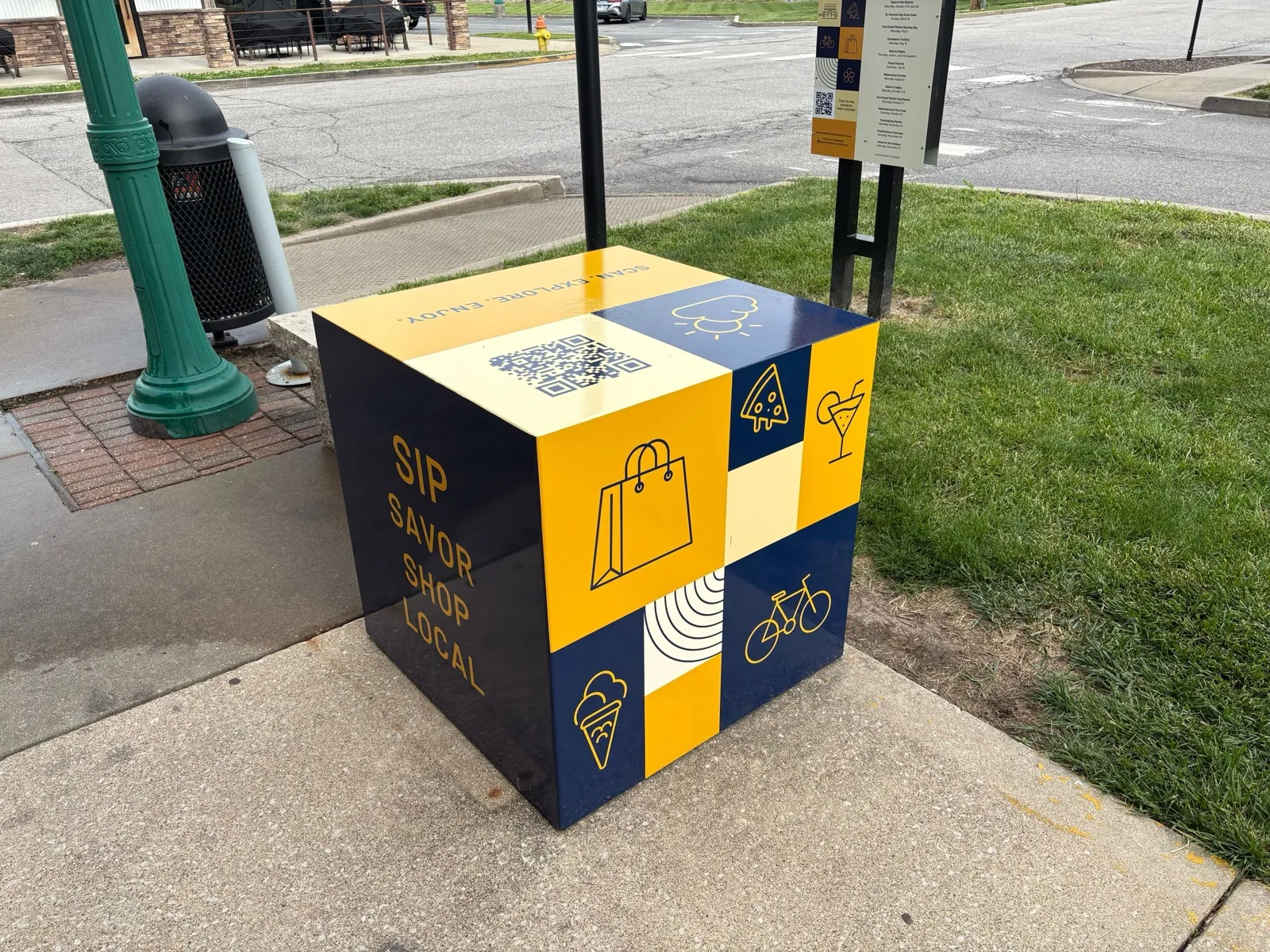 Blue O'Fallon Downtown District branded box on a downtown sidewalk