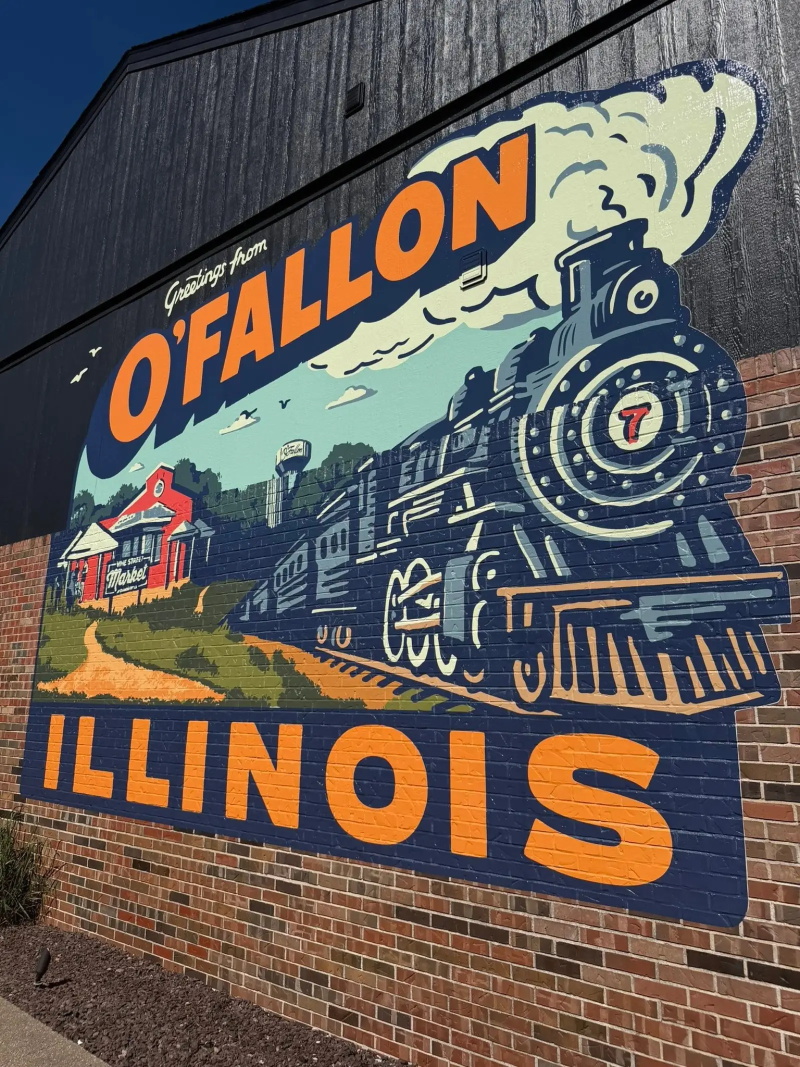 Close-up of the O'Fallon downtown mural showing a train emerging from a tunnel