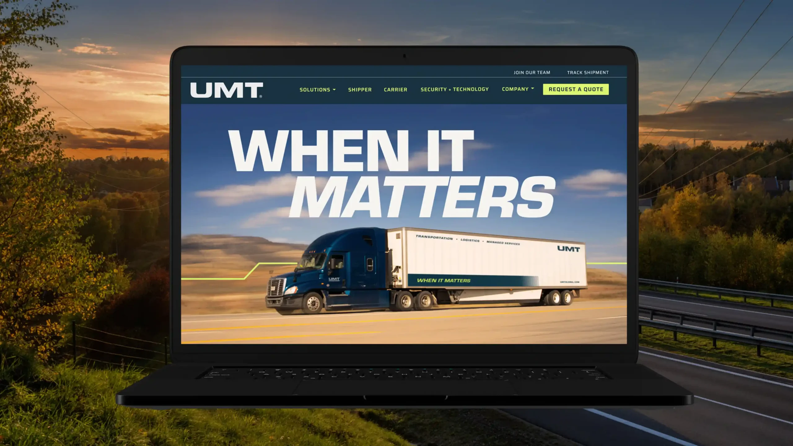 UMT website homepage displayed on a laptop screen with a sunset highway in the background